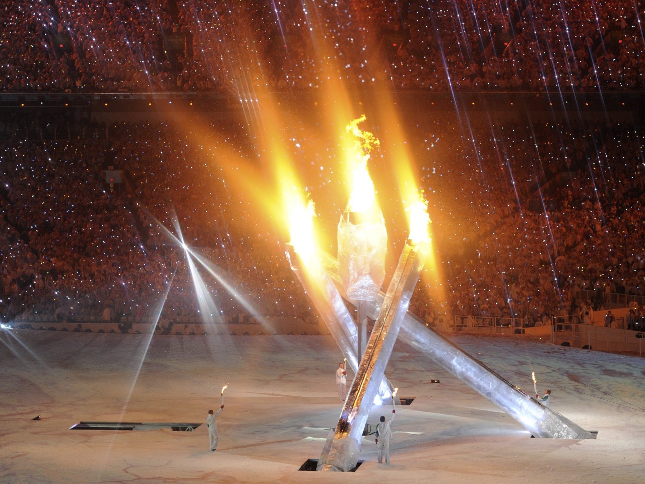 Олимпийский огонь современных игр зажигается. Зажжение олимпийского огня. Церемония зажжения олимпийского огня. Олимпийский огонь Ванкувер 2010. Зажжение олимпийского огня в Барселоне 1992.